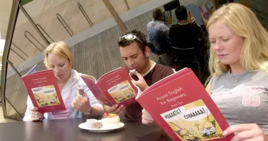 Three people eating and reading books