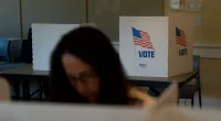 FILE - A voter in the foreground casts her ballots during the Republican primary election in Wilson, Wyo., Aug. 16, 2022. Relatively few Americans are excited about a potential rematch of the 2020 election between President Joe Biden and Donald Trump. But more Republicans would be happy to have Trump as their nominee than Democrats would be with Biden. That