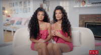 Gabriella and Catherine, both dressed in pink and sitting on a white couch, in