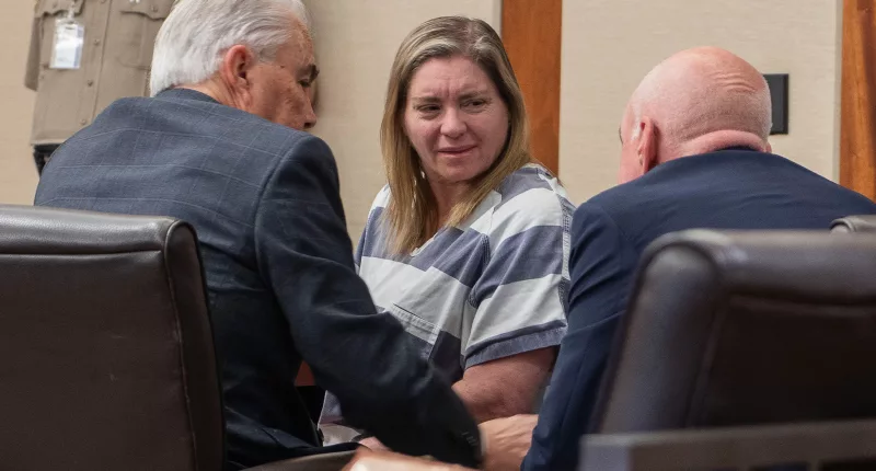 Jodi Hildebrandt speaks to two men in court.