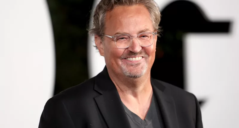 Smiling Photo of Mathew Perry wearing a black blazer