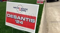 Yard signs promoting Florida Gov. Ron DeSantis in 2024, financed by the super PAC promoting DeSantis for president, line the street leading up to a Republican congressional fundraiser on May 13. 2023, in Sioux Center, Iowa. The super PAC, Never Back Down, is taking on the labor-intensive task of organizing support in the 2024 Iowa caucuses for DeSantis, though barred by law from coordinating with the candidate. (AP Photo/Tom Beaumont)