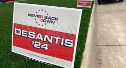 Yard signs promoting Florida Gov. Ron DeSantis in 2024, financed by the super PAC promoting DeSantis for president, line the street leading up to a Republican congressional fundraiser on May 13. 2023, in Sioux Center, Iowa. The super PAC, Never Back Down, is taking on the labor-intensive task of organizing support in the 2024 Iowa caucuses for DeSantis, though barred by law from coordinating with the candidate. (AP Photo/Tom Beaumont)
