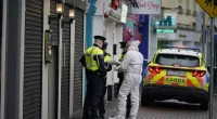 A forensic investigator speaks to garda officers at the scene in Blanchardstown, Dublin, this morning