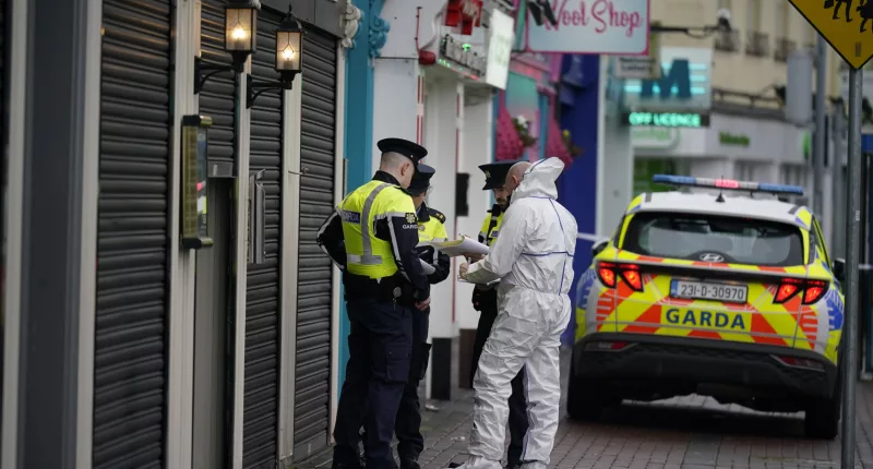 A forensic investigator speaks to garda officers at the scene in Blanchardstown, Dublin, this morning