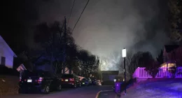 Smoke rises over a neighborhood where Virginia police say a house exploded as officers were trying to serve a search warrant on Monday, Dec. 4, 2023, in Arlington, Va. (AP Photo/Matthew Barakat)