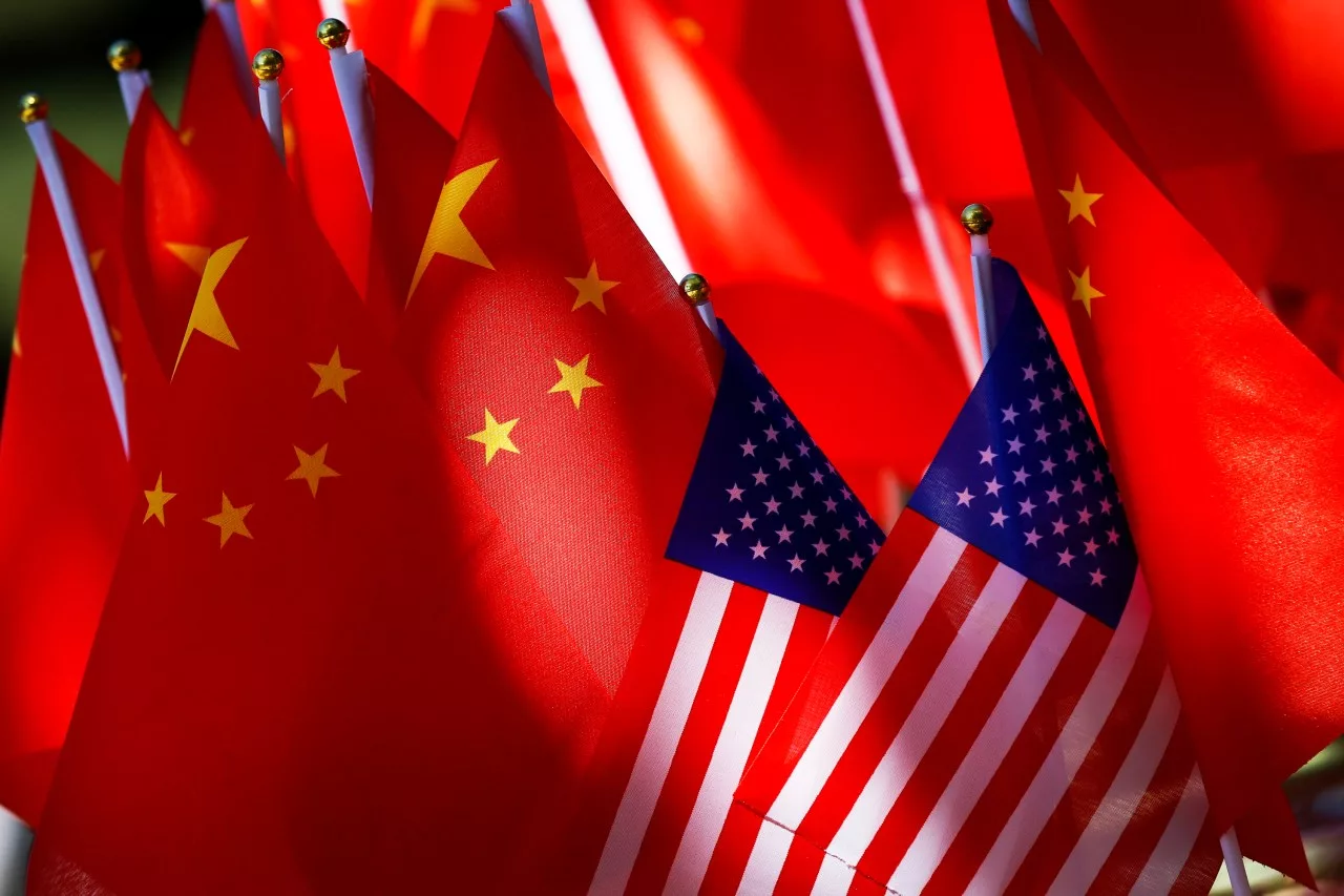 FILE - The flags of the U.S. and Chinese are displayed together on top of a trishaw in Beijing on Sept. 16, 2018. Lawmakers intent on reducing China’s influence on the U.S. economy are looking to broaden the effort internationally by requiring the U.S. Treasury to form a plan that reduces Beijing’s role at the Inter-American Development Bank. (AP Photo/Andy Wong, File)