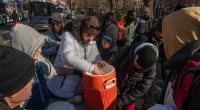 Grim photos show huge line of migrants outside processing center