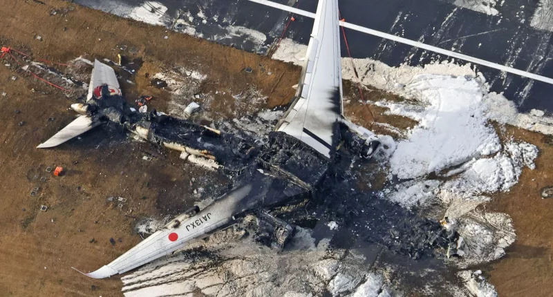 The charred wreckage of the Japan Airlines plane at Haneda airport