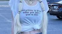 Tori Spelling wears rude shirt that flashes her tummy then flips the bird after McDermott split: 'Everything is great when you don't give a s***'