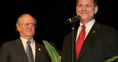 FILE - Tom Parker, left, listens as former Alabama Supreme Court Chief Justice Roy Moore, right, addresses the crowd at the Davis Theater in Montgomery, Ala. on Jan. 14, 2005, before swearing in Parker as an associate justice of the court. When the Alabama Supreme Court ruled that frozen embryos are children, its Chief Justice Tom Parker made explicit use of Christian theology to justify the court