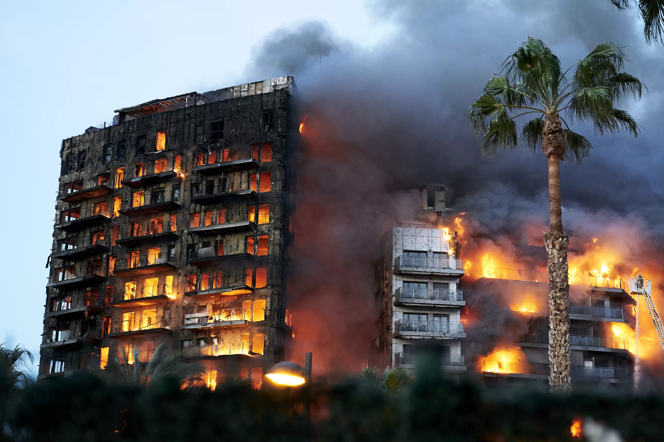 At least four are dead and 14 missing after the huge blaze engulfed to residential buildings in the Spanish city