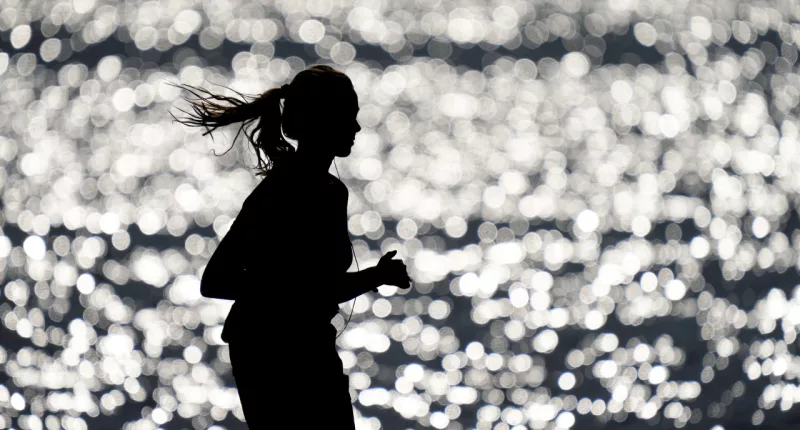 FILE - A runner makes her way along the path at Gray