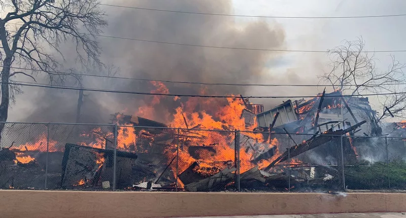 More than 100 firefighters tackle abandoned building blaze that spread to hotel