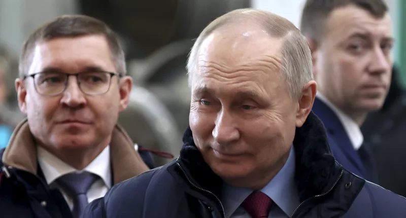 Vladimir Putin visits a plant in, Russia today and smiles to himself as he makes the rounds