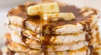 a stack of cinnamon cloud bread pancakes with syrup and butter