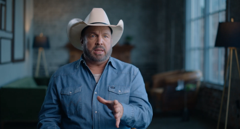 Garth Brooks speaks to the camera while wearing a hat.