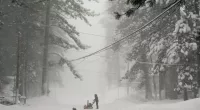 A person tries to clear snow from a road during a storm in Truckee, California on Saturday