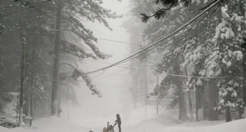 A person tries to clear snow from a road during a storm in Truckee, California on Saturday