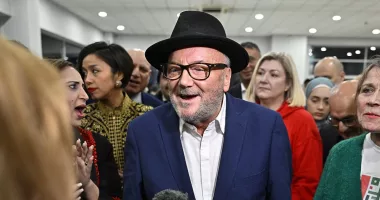 Inside George Galloway's chaotic victory party: Rochdale's new MP compares himself to Cristiano Ronaldo and gives guests bottles of Irn-Bru in celebration at Suzuki car showroom
