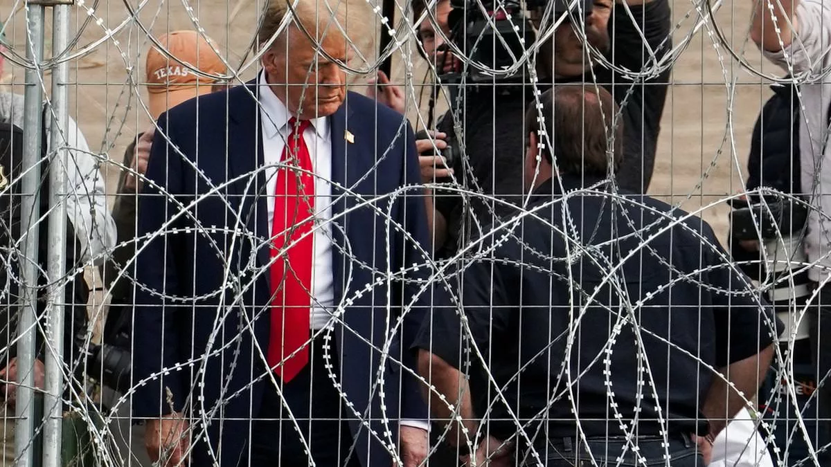 Trump waves at migrants through barbed wire fence at Mexican border