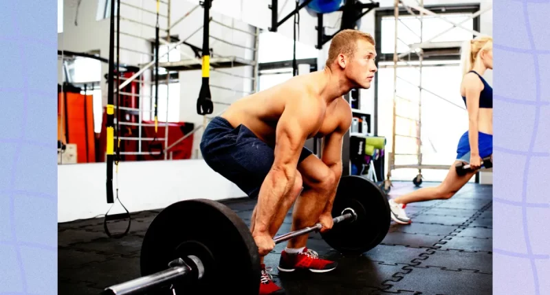 muscular man doing barbell deadlift at the gym