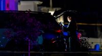 An investigator takes photographs as she examines a vehicle at a scene where four people were found dead in West Haven, Utah on Tuesday, September 3, 2024