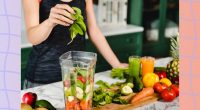 close-up of woman making fresh juice in blender with vegetables