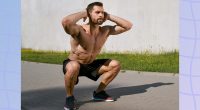 fit, muscular man doing bodyweight squats outdoors
