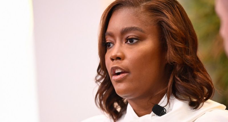 Rashida Jones speaking at a conference.