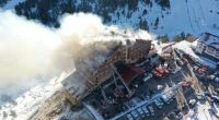 Aerial view of a hotel fire with fire trucks and ambulances responding.