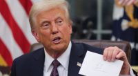 President Trump holding a letter in the Oval Office.