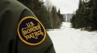 U.S. Border Patrol agent's uniform patch and snowy border landscape.