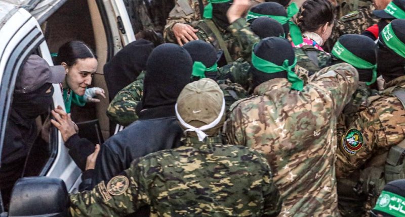 Al-Qassam Brigades members hand over an Israeli hostage to the Red Cross.