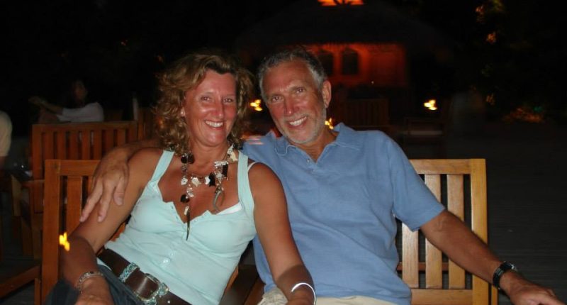 A couple sitting together outdoors at night.