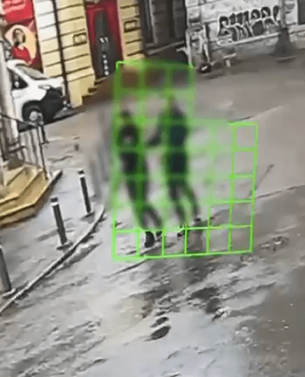 Blurry image of a person walking in a puddle.