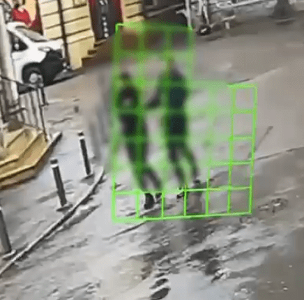 Blurry image of a person walking in a puddle.