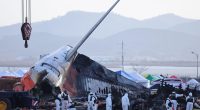 A police forensic team conducts an on-site investigation at the scene of the Jeju Air crash