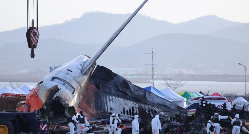 A police forensic team conducts an on-site investigation at the scene of the Jeju Air crash