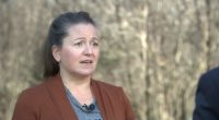 Woman speaking outdoors about a lawsuit against her HOA.