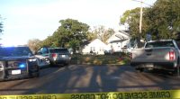 Crime scene with police cars and yellow tape.