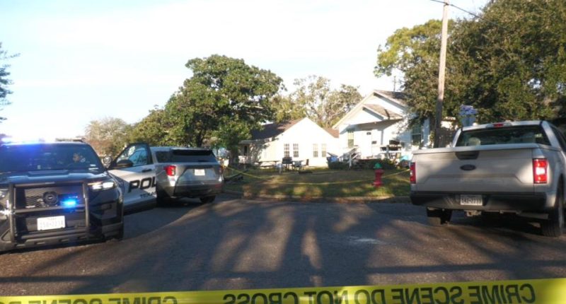 Crime scene with police cars and yellow tape.