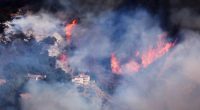 A house is threatened as the Palisades Fire grows in the mountains in the community of Topanga, California