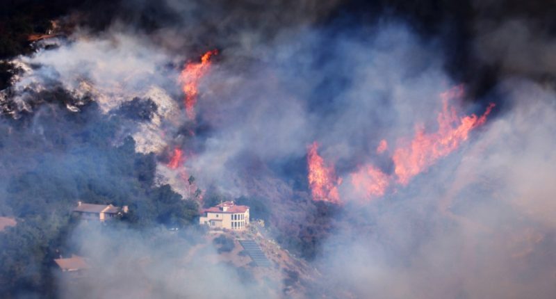 A house is threatened as the Palisades Fire grows in the mountains in the community of Topanga, California