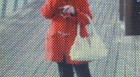 Low-resolution image of a person in a red coat.