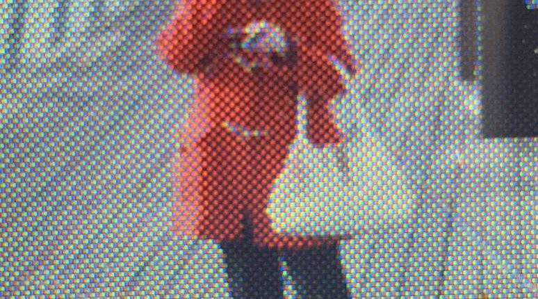 Low-resolution image of a person in a red coat.