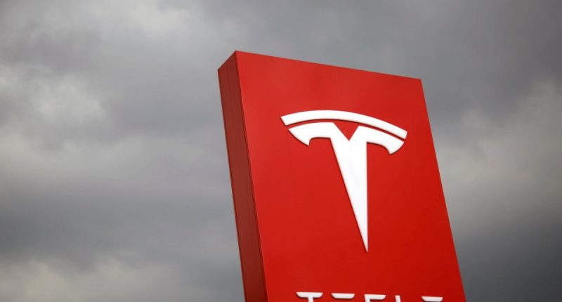Tesla logo on a red sign.