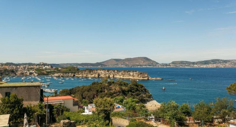 Overlooking the Gulf of Pozzuoli, boats are in the bay near Punta Pennata rocks.