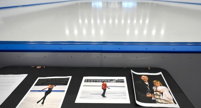 Photos of figure skaters Jinna Han, Spencer Lane, and coaches Vadim Naumov and Evgenia Shishkova displayed at an ice rink.
