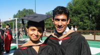 Two graduates in academic regalia.